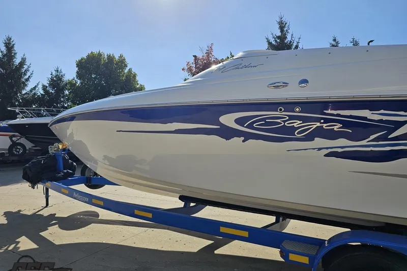 Slide: The Image of 2004 Baja 29 Outlaw boat on trailer, featuring sleek design and blue graphics. - 21