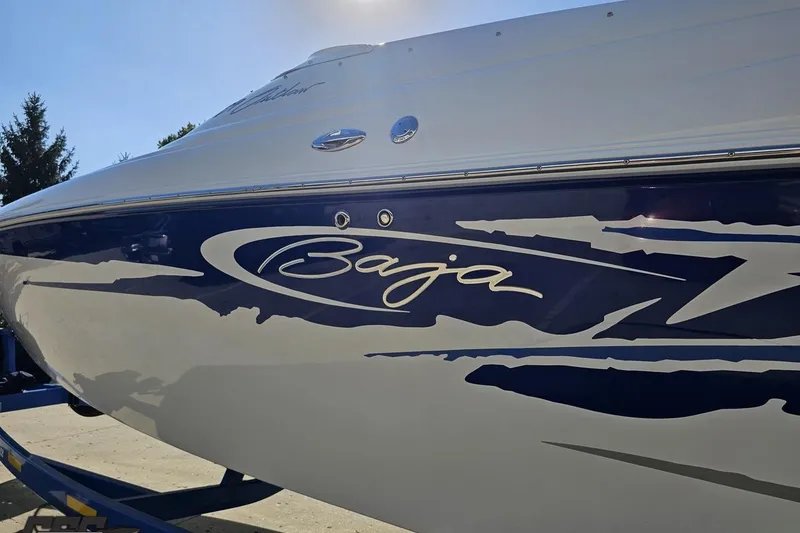 Slide: The Image of 2004 Baja 29 Outlaw boat with sleek blue and white design. - 22