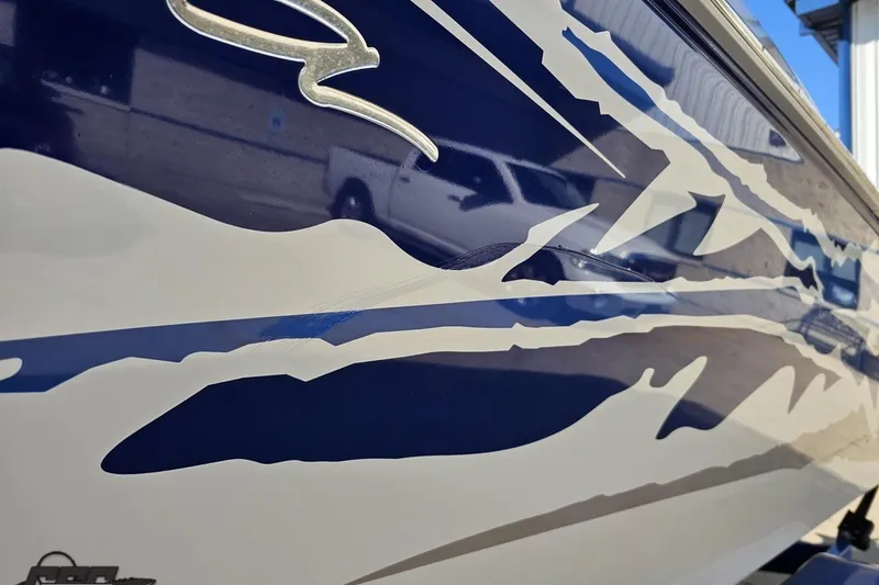 Slide: The Image of 2004 Baja 29 Outlaw boat with dynamic blue and white graphics on the hull. - 23