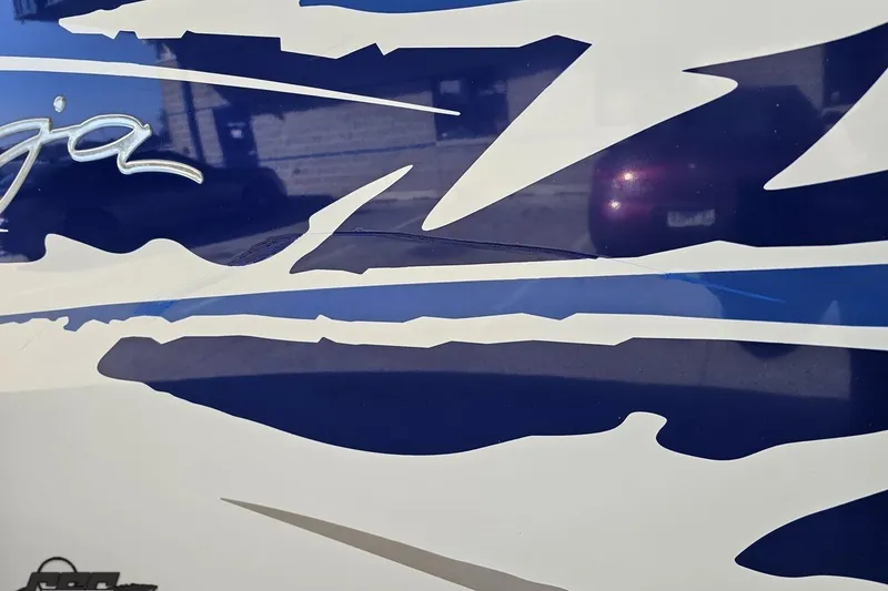 Slide: The Image of 2004 Baja 29 Outlaw boat with blue and white graphic design detail. - 24