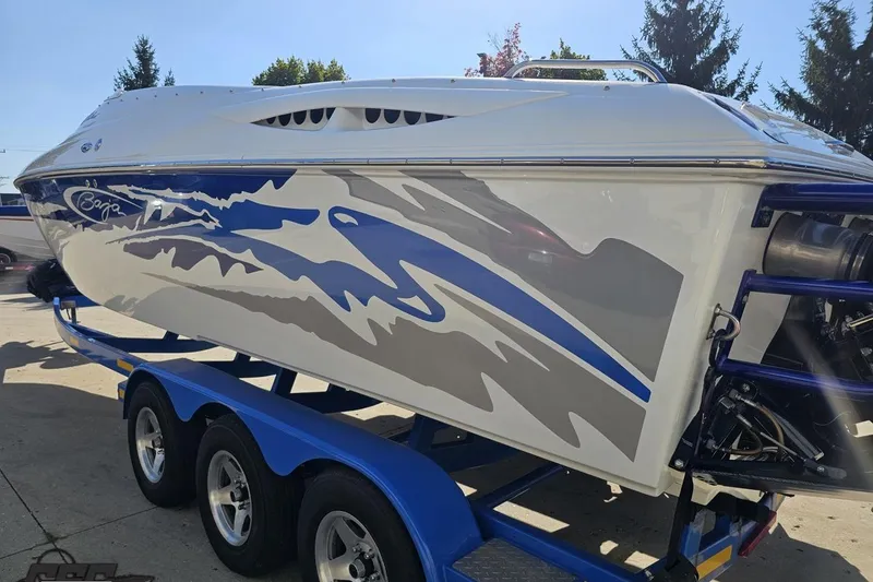 Slide: The Image of 2004 Baja 29 Outlaw speedboat with blue and gray graphics on a trailer. - 26
