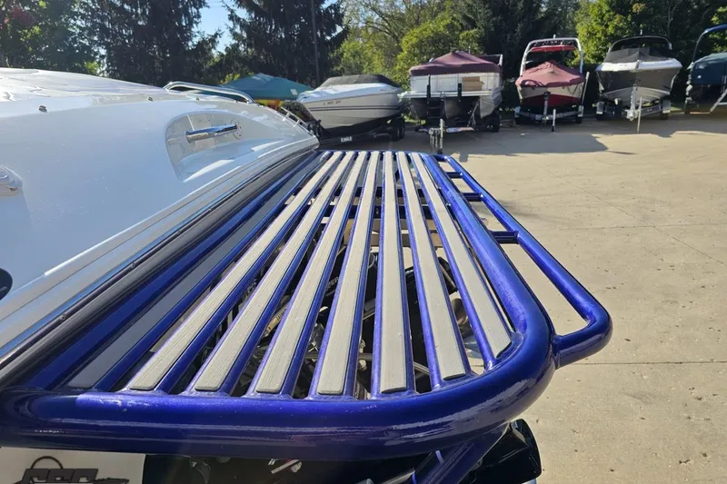 Slide: The Image of 2004 Baja 29 Outlaw boat with blue swim platform, parked among other boats. - 28