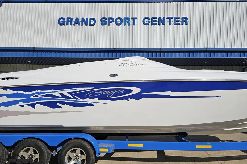 Slide: The Image of 2004 Baja 29 Outlaw boat at Grand Sport Center, featuring blue and white design. - 3