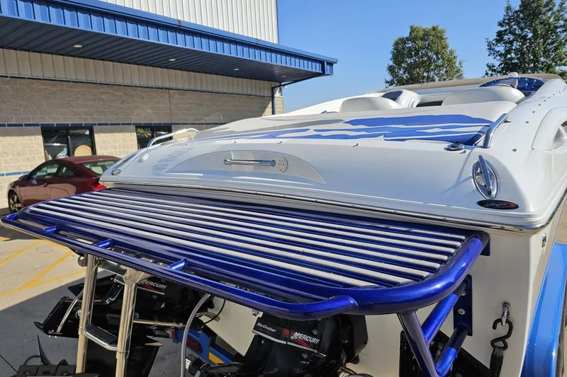 Slide: The Image of 2004 Baja 29 Outlaw boat with blue accents, parked near a building. - 30