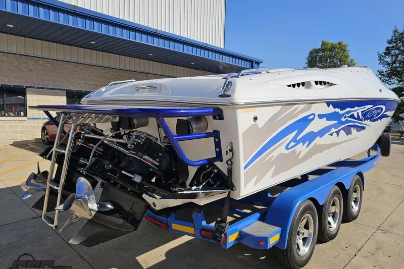 Slide: The Image of 2004 Baja 29 Outlaw boat on trailer, featuring vibrant blue and white design. - 31