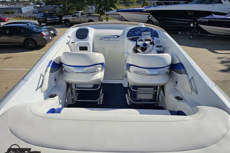 Slide: The Image of 2004 Baja 29 Outlaw boat interior with white and blue seating, parked outdoors. - 41
