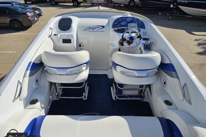 Slide: The Image of 2004 Baja 29 Outlaw boat interior with white and blue seating, steering wheel, and dashboard. - 42