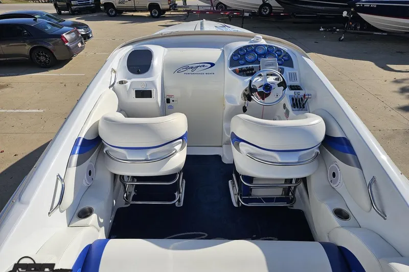 Slide: The Image of 2004 Baja 29 Outlaw boat interior with white and blue seating, steering wheel, and dashboard. - 43