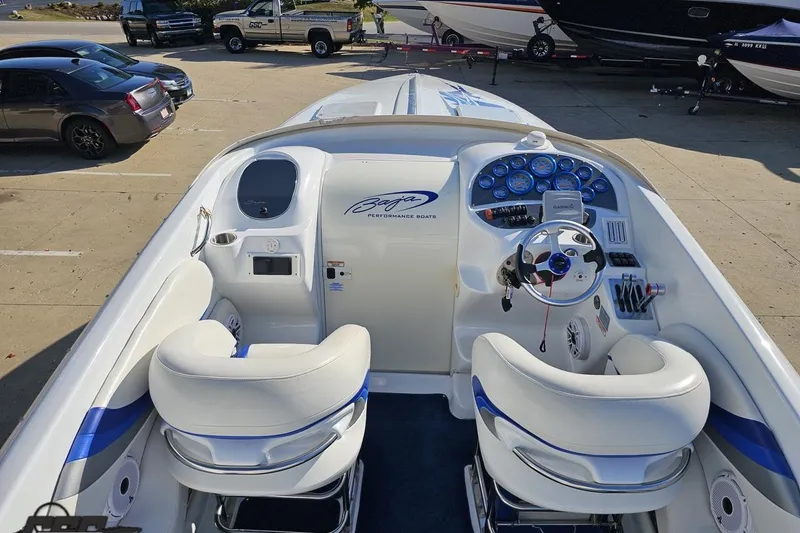 Slide: The Image of 2004 Baja 29 Outlaw boat interior with white and blue seating, dashboard, and steering wheel. - 44