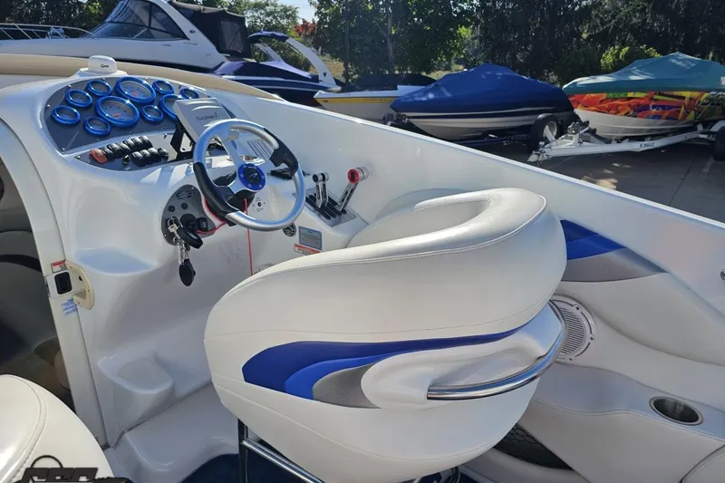 Slide: The Image of 2004 Baja 29 Outlaw boat cockpit with white and blue seating, steering wheel, and control panel. - 48