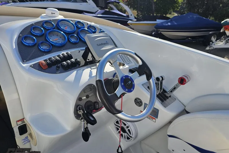 Slide: The Image of 2004 Baja 29 Outlaw boat dashboard with Garmin GPS and blue-accented gauges. - 53