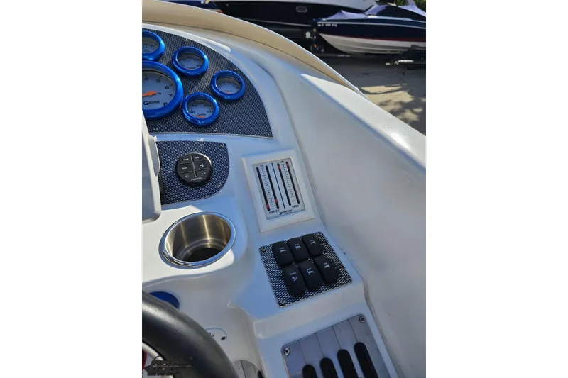 Slide: The Image of 2004 Baja 29 Outlaw boat dashboard with gauges and controls, featuring blue accents. - 55