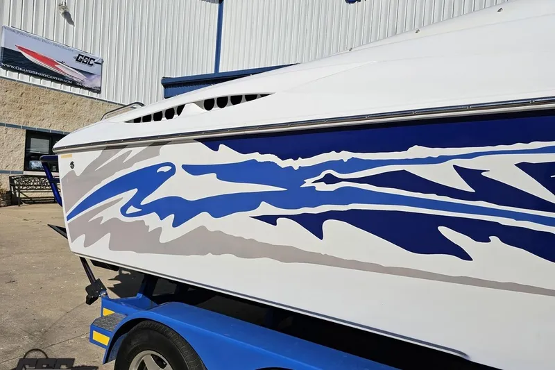 Slide: The Image of 2004 Baja 29 Outlaw boat with blue and gray graphics on a trailer. - 6