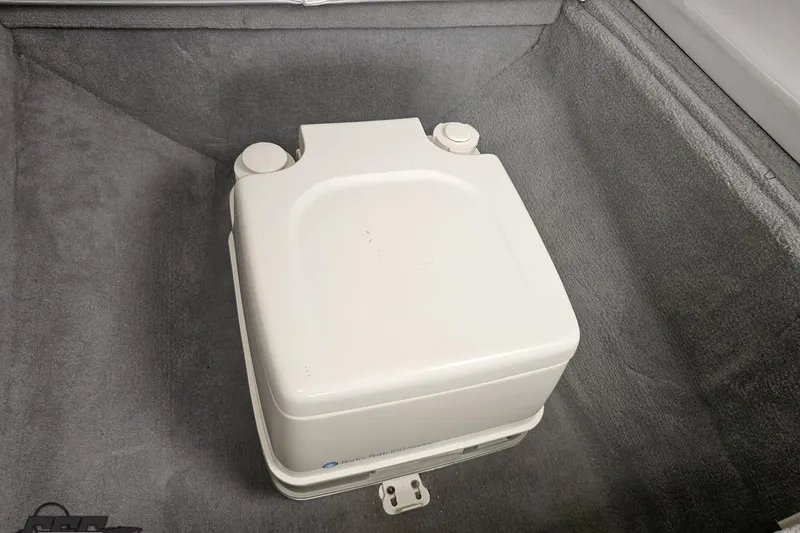 Slide: The Image of Portable toilet in 2004 Baja 29 Outlaw boat interior, on gray carpeted floor. - 64