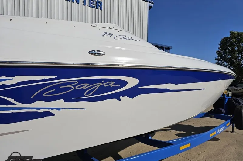 Slide: The Image of 2004 Baja 29 Outlaw boat with blue and white design on trailer. - 7
