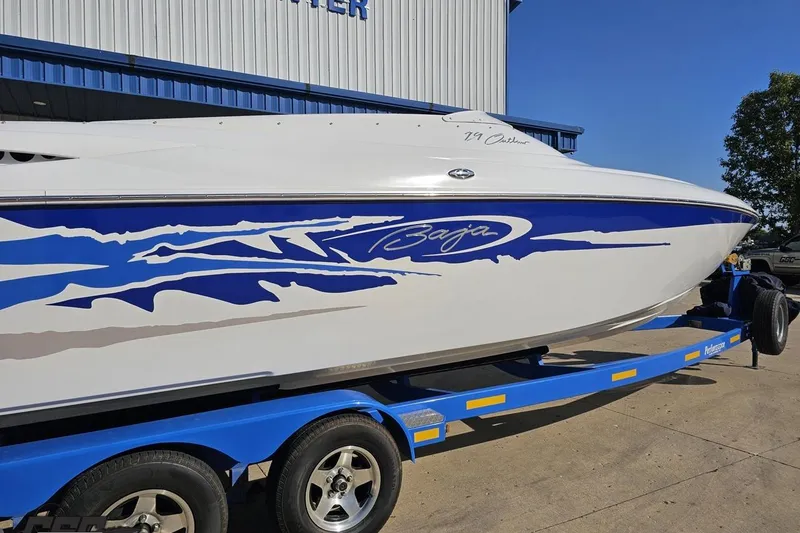 Slide: The Image of 2004 Baja 29 Outlaw speedboat on a blue trailer, featuring dynamic blue graphics. - 8