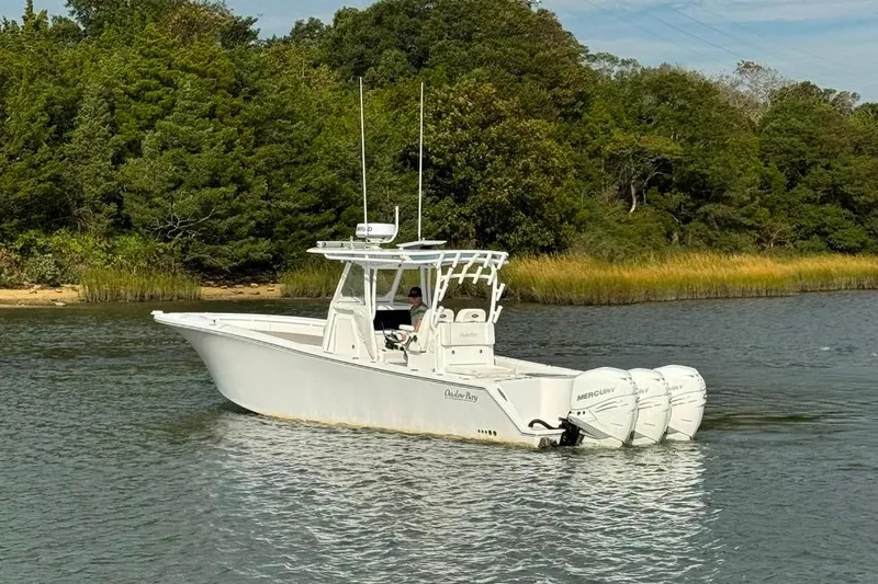 Slide: The Image of 2019 Onslow Bay 33 Tournament boat with triple Mercury engines on a calm river. - 10