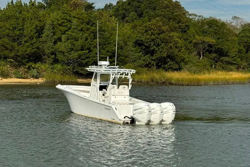 Slide: The Image of 2019 Onslow Bay 33 Tournament boat with triple 400 engines on a calm river. - 11