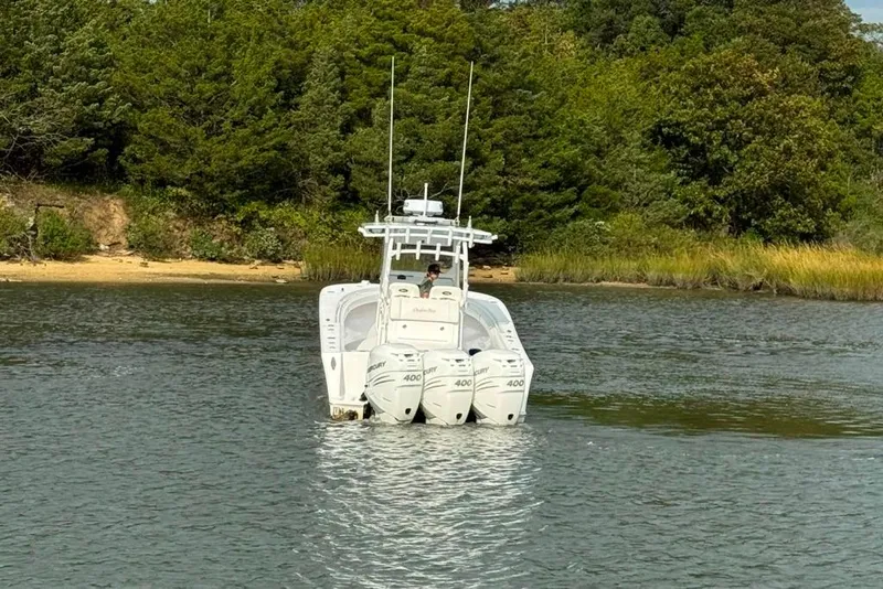 Slide: The Image of 2019 Onslow Bay 33 Tournament boat on calm water near a wooded shoreline. - 12