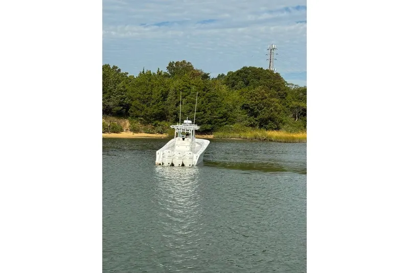 Slide: The Image of 2019 Onslow Bay 33 Tournament boat on water near lush green shoreline. - 13
