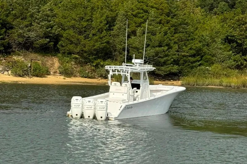 Slide: The Image of 2019 Onslow Bay 33 Tournament boat on water near lush green shoreline. - 15