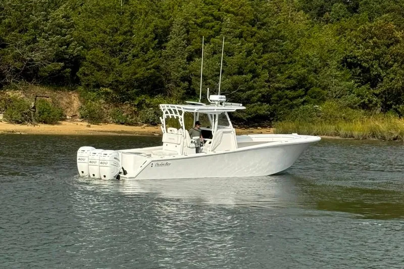 Slide: The Image of 2019 Onslow Bay 33 Tournament boat on calm water near a wooded shoreline. - 16