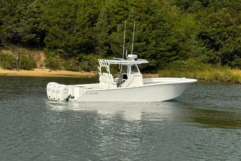 Slide: The Image of 2019 Onslow Bay 33 Tournament boat cruising near lush shoreline. - 17