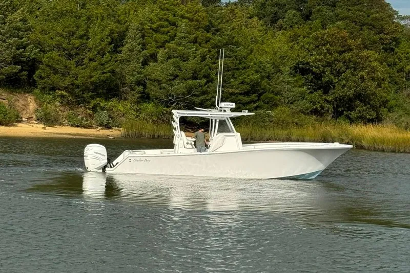 Slide: The Image of 2019 Onslow Bay 33 Tournament boat on a serene lake with lush greenery. - 19
