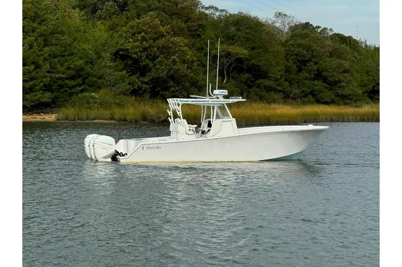 Slide: The Image of 2019 Onslow Bay 33 Tournament boat on calm water, surrounded by lush greenery. - 2