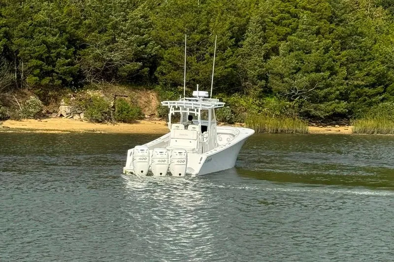 Slide: The Image of 2019 Onslow Bay 33 Tournament boat cruising near a lush, green shoreline. - 21