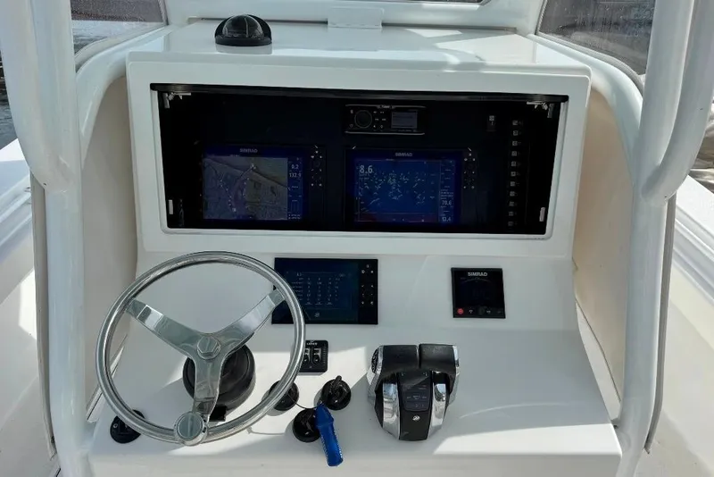 Slide: The Image of 2019 Onslow Bay 33 Tournament boat console with steering wheel and navigation screens. - 27