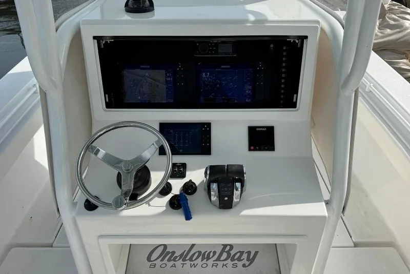 Slide: The Image of 2019 Onslow Bay 33 Tournament boat console with steering wheel and navigation screens. - 28