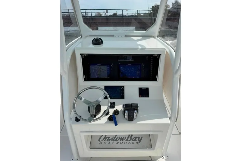 Slide: The Image of 2019 Onslow Bay 33 Tournament boat dashboard with navigation screens and steering wheel. - 29