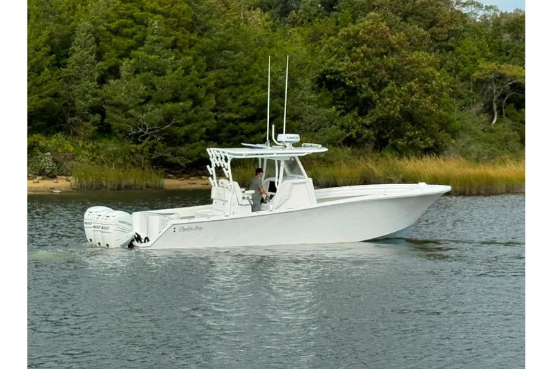 Slide: The Image of 2019 Onslow Bay 33 Tournament boat cruising on a calm river near lush greenery. - 3