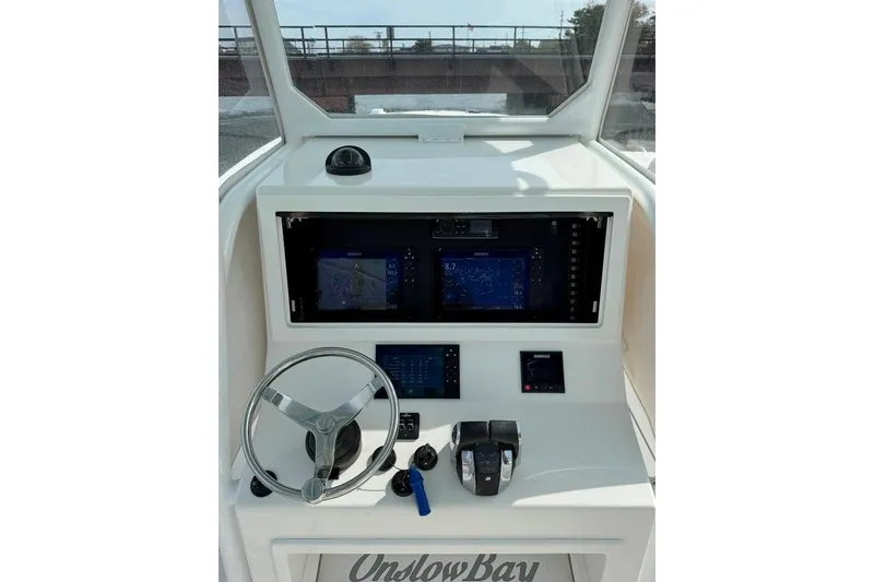 Slide: The Image of 2019 Onslow Bay 33 Tournament boat dashboard with steering wheel and Simrad navigation displays. - 30