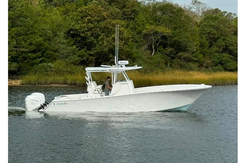 Slide: The Image of 2019 Onslow Bay 33 Tournament boat cruising on a calm river with lush greenery. - 4