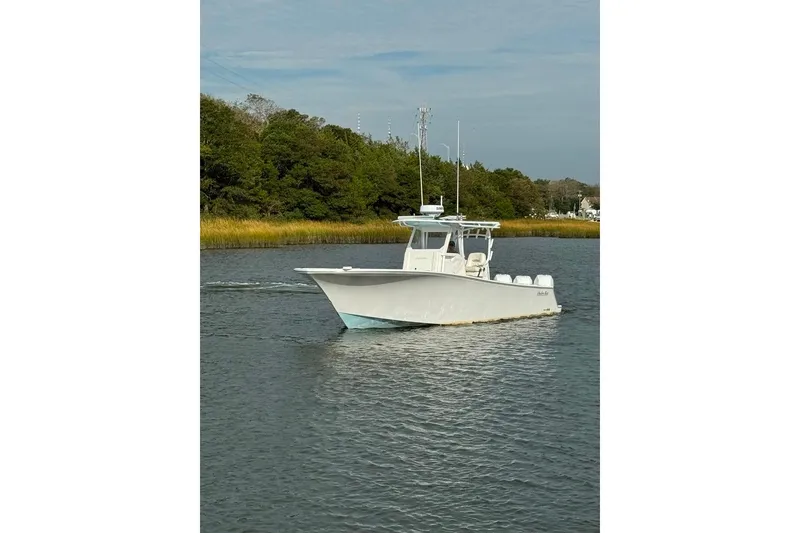 Slide: The Image of 2019 Onslow Bay 33 Tournament boat on calm water, surrounded by lush greenery. - 7