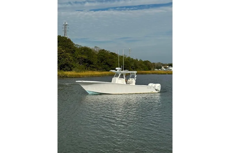Slide: The Image of 2019 Onslow Bay 33 Tournament boat on calm water near lush green shoreline. - 9