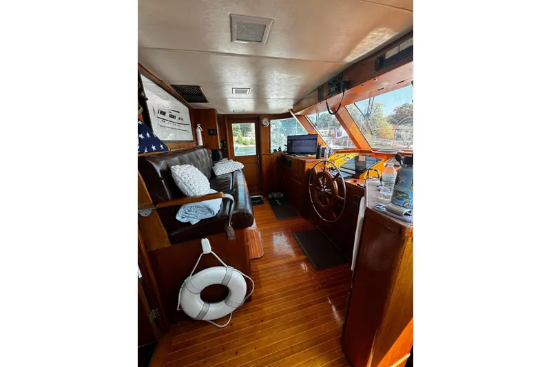 Slide: The Image of 1987 Burger Motoryacht interior with wooden helm, seating, and navigation equipment. - 10