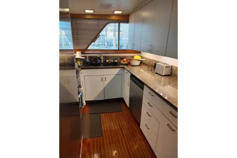 Slide: The Image of 1987 Burger Motoryacht kitchen with modern appliances, granite countertops, and wooden flooring. - 17