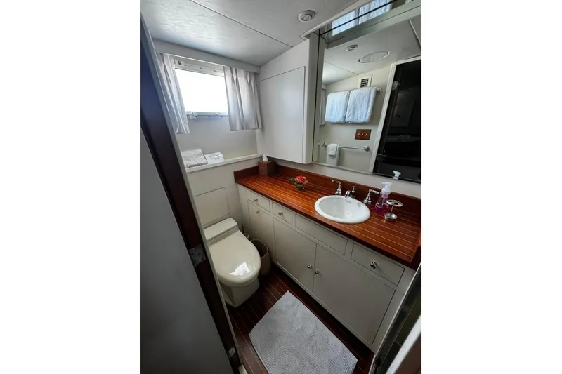 Slide: The Image of Luxurious bathroom in a 1987 Burger Motoryacht with wooden countertop and modern fixtures. - 19