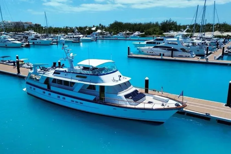 Slide: The Image of 1987 Burger Motoryacht docked in a vibrant marina with clear blue water. - 4