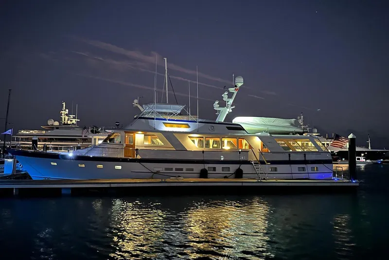 Slide: The Image of 1987 Burger Motoryacht illuminated at night, docked in a serene marina setting. - 6