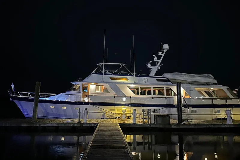 Slide: The Image of 1987 Burger Motoryacht docked at night, illuminated with warm lights. - 8