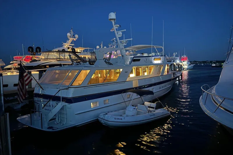 Slide: The Image of 1987 Burger Motoryacht docked at night, illuminated with warm lights. - 9