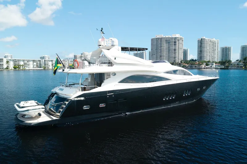 Slide: The Image of 2008 Sunseeker 90 Yacht on calm water with city skyline backdrop. - 10
