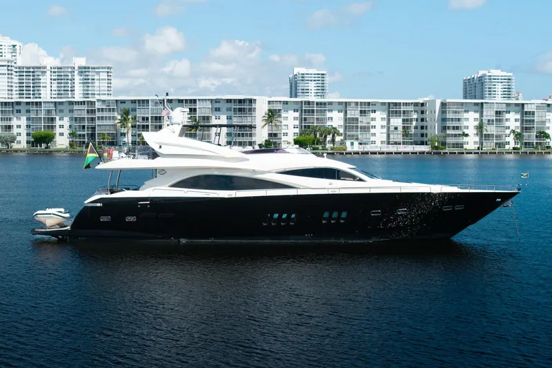 Slide: The Image of 2008 Sunseeker 90 Yacht on water, modern buildings in background. - 11