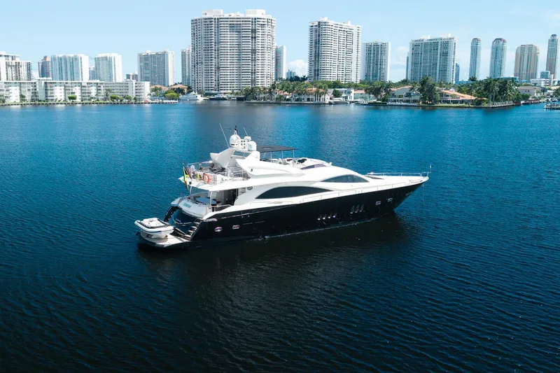 Slide: The Image of 2008 Sunseeker 90 Yacht cruising in a city harbor with skyscrapers in the background. - 23