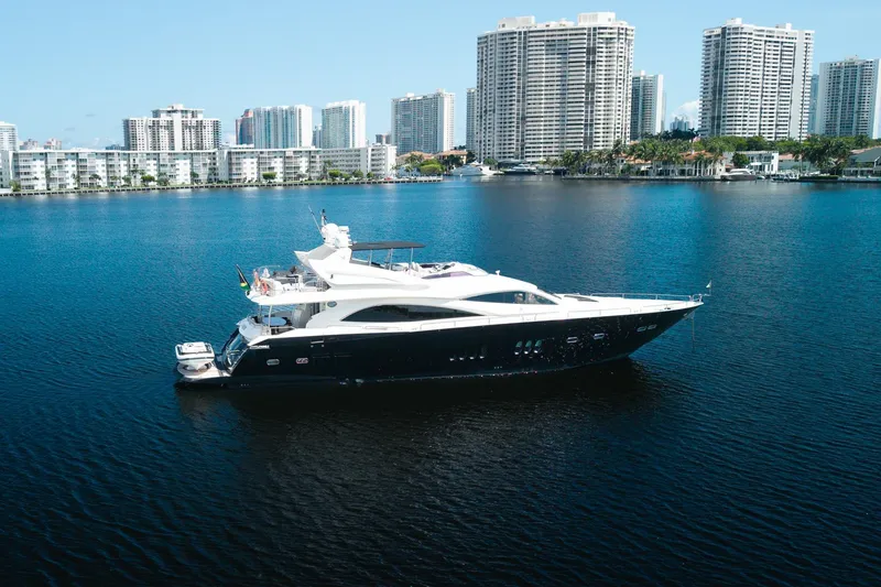 Slide: The Image of 2008 Sunseeker 90 Yacht on calm water with city skyline backdrop. - 24