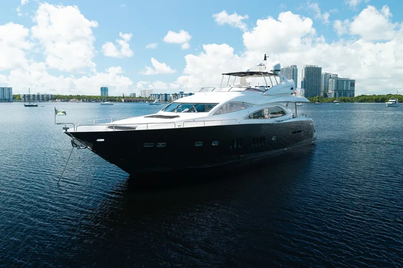 Slide: The Image of 2008 Sunseeker 90 Yacht cruising on a sunny day with city skyline backdrop. - 5